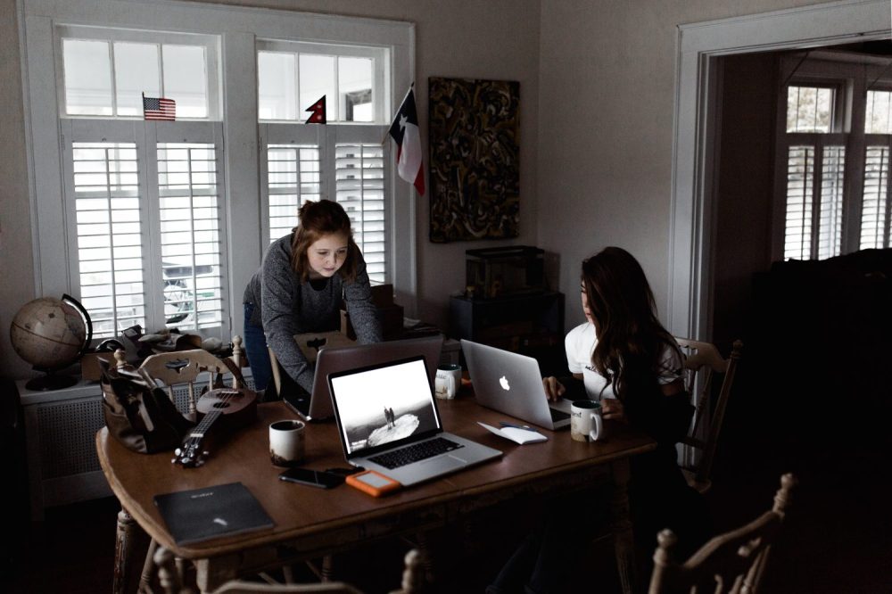 Two women working together on laptops